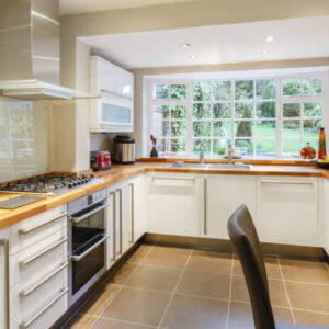 Modular modern kitchen interior with white units and contemporary dining area